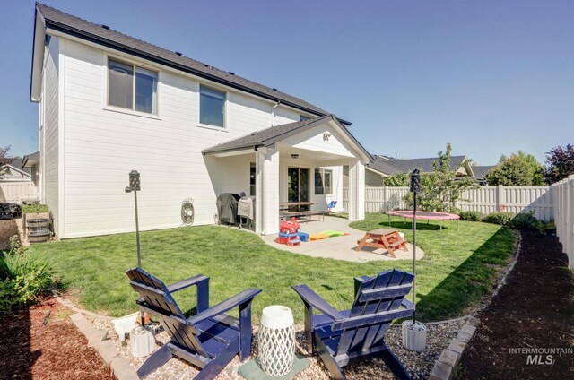 rear view of house with a patio area and a trampoline