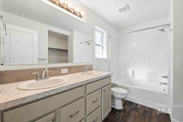 full bathroom featuring toilet, shower / washtub combination, vanity, hardwood / wood-style flooring, and backsplash