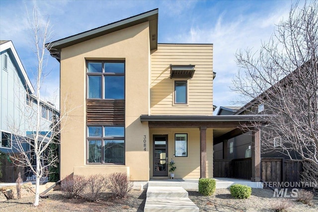 contemporary home featuring stucco siding and covered porch