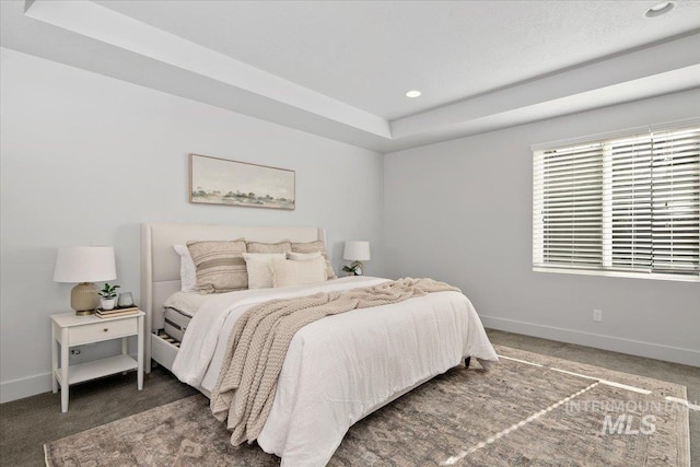 bedroom featuring recessed lighting, a tray ceiling, baseboards, and carpet