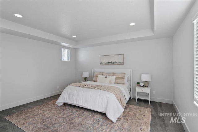 bedroom with recessed lighting, a tray ceiling, baseboards, and carpet floors