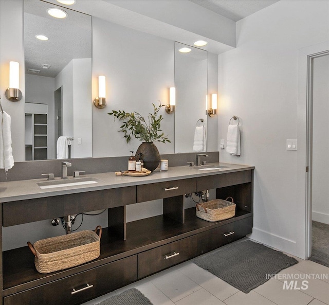 bathroom with double vanity, recessed lighting, tile patterned floors, and a sink