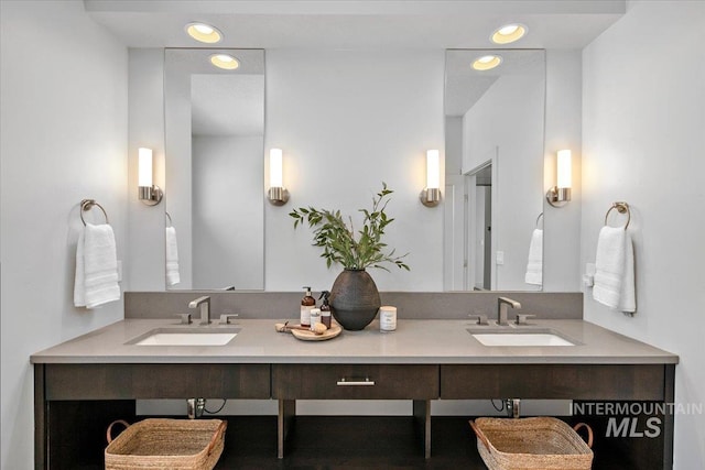 full bathroom with double vanity, recessed lighting, and a sink