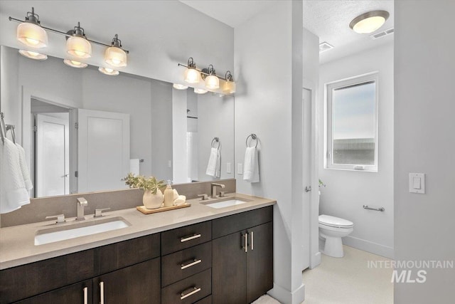 bathroom featuring a sink, visible vents, toilet, and double vanity