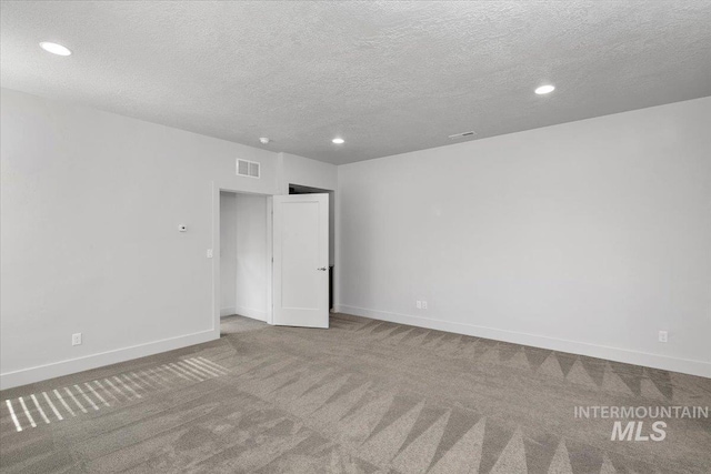 carpeted spare room with recessed lighting, baseboards, visible vents, and a textured ceiling