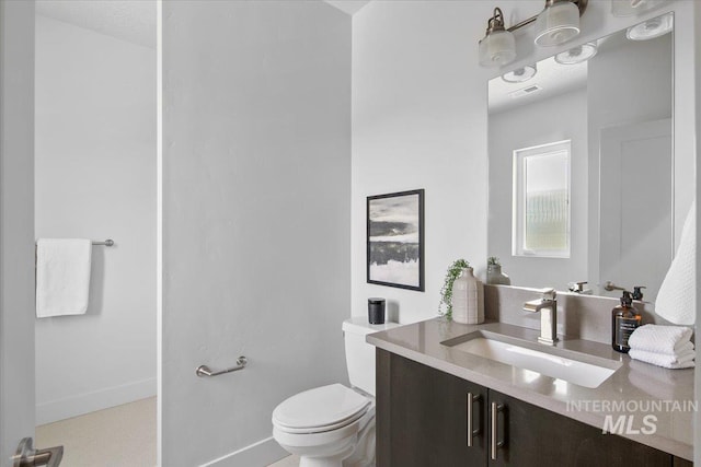 bathroom featuring visible vents, toilet, vanity, and baseboards