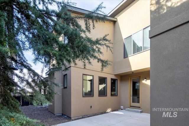 back of house featuring a patio area and stucco siding