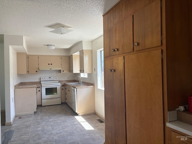 kitchen featuring white appliances, light countertops, a textured ceiling, baseboards, and visible vents