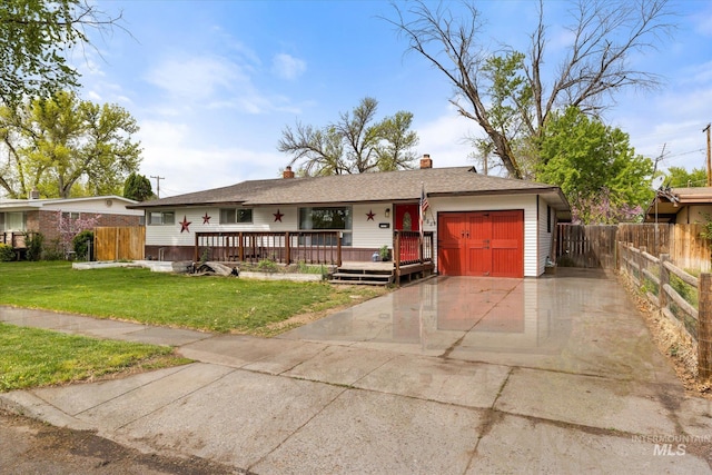 ranch-style home featuring an attached garage, a front lawn, fence, and concrete driveway