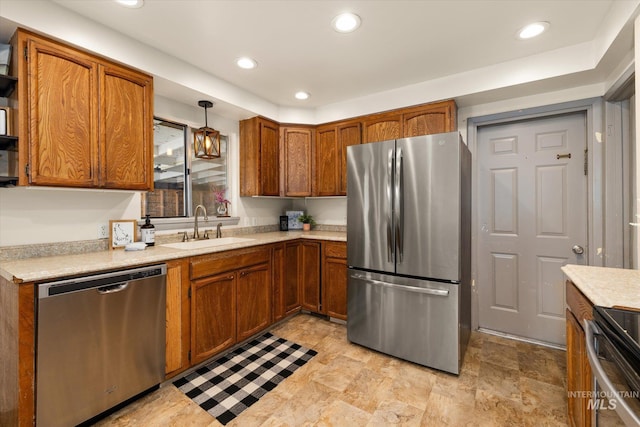 kitchen featuring light countertops, stainless steel appliances, brown cabinetry, and a sink