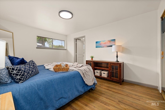 bedroom featuring baseboards and wood finished floors