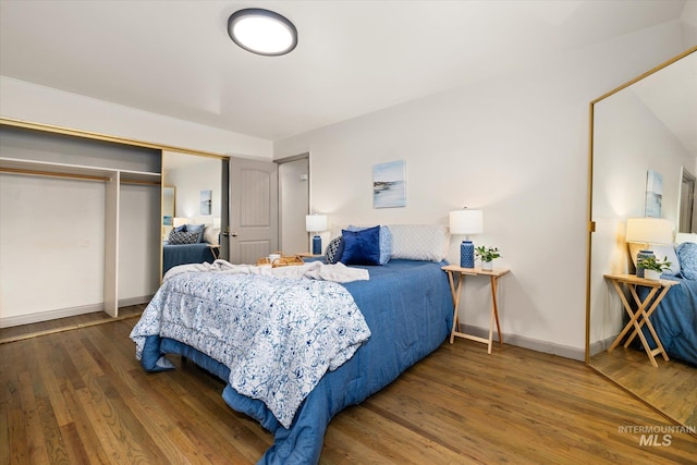 bedroom with baseboards, a closet, and wood finished floors