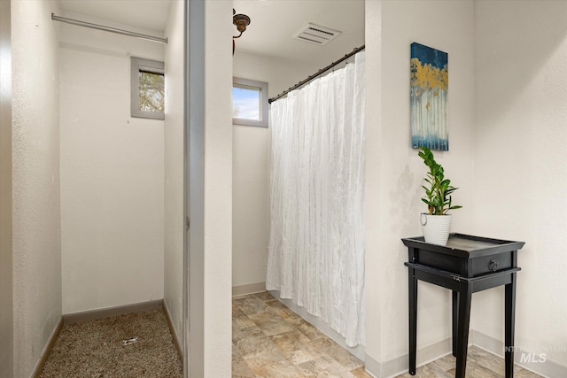 bathroom with visible vents, baseboards, and a shower with curtain