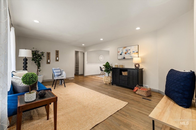 living area featuring recessed lighting, baseboards, and wood finished floors