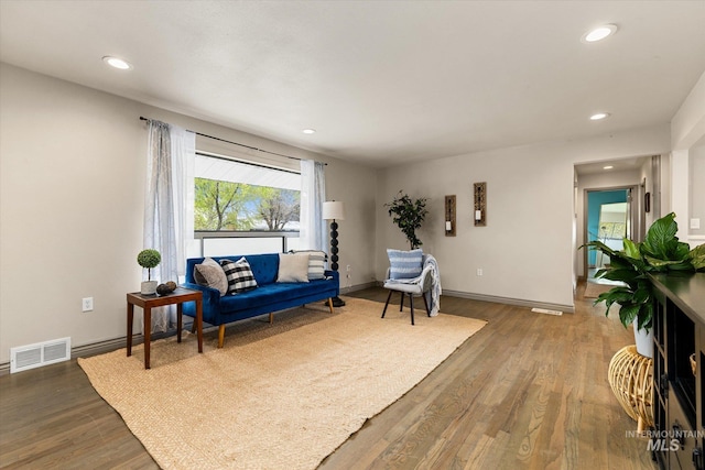 living area with recessed lighting, wood finished floors, and visible vents