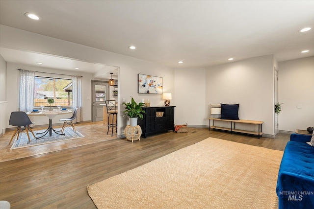 living area featuring baseboards, recessed lighting, and wood finished floors
