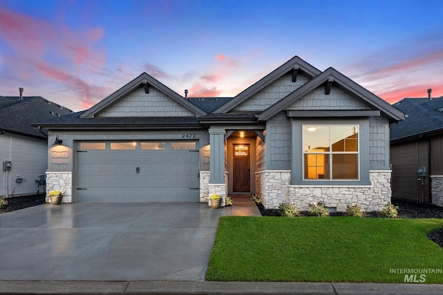 craftsman-style home featuring a garage and a yard