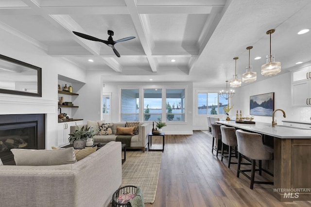 living room featuring coffered ceiling, sink, dark hardwood / wood-style floors, beamed ceiling, and ceiling fan