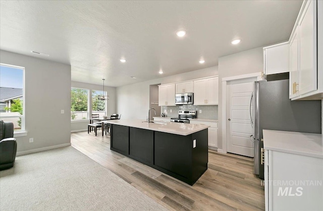5094 W Avilla Dr, Meridian, ID 83646 - kitchen featuring appliances with stainless steel finishes, white cabinets, light countertops, light wood-style floors, and recessed lighting