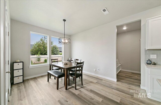 5094 W Avilla Dr, Meridian, ID 83646 - dining room with light wood finished floors, baseboards, and a chandelier