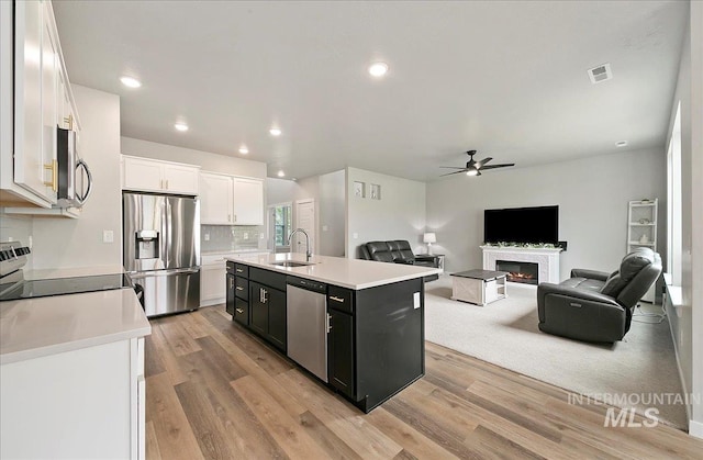 5094 W Avilla Dr, Meridian, ID 83646 - kitchen with stainless steel appliances, a sink, a ceiling fan, white cabinets, and light countertops