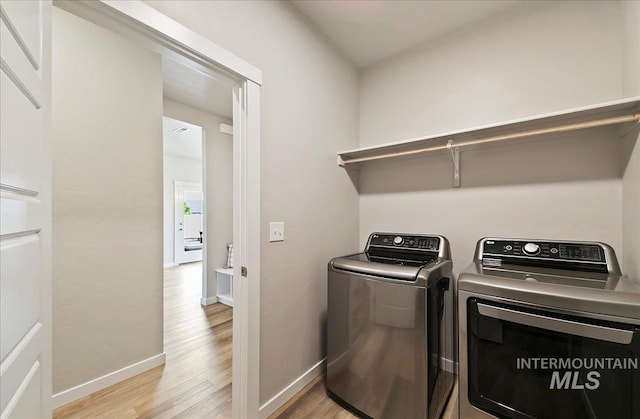 5094 W Avilla Dr, Meridian, ID 83646 - laundry area featuring washing machine and dryer, light wood-style floors, and baseboards