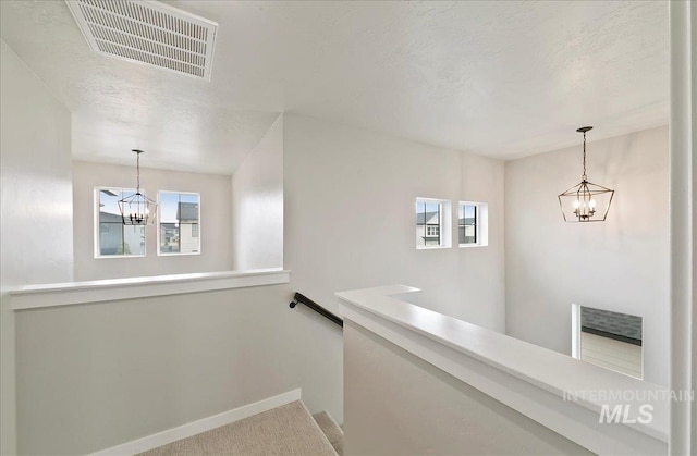 5094 W Avilla Dr, Meridian, ID 83646 - hallway featuring a chandelier, an upstairs landing, baseboards, and carpet floors