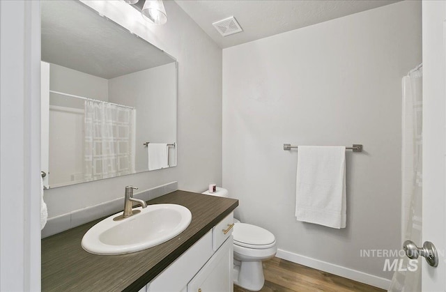 5094 W Avilla Dr, Meridian, ID 83646 - bathroom featuring wood finished floors, toilet, baseboards, vanity, and a shower with shower curtain