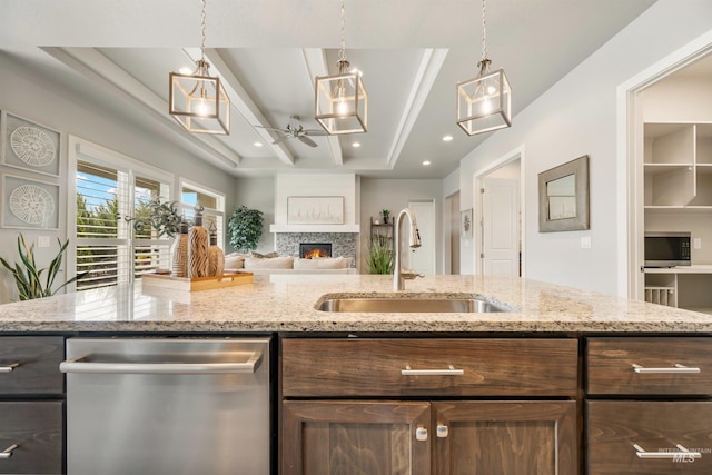 1071 W Rose Quartz St, Kuna, ID 83634 - kitchen featuring stainless steel appliances, a sink, ceiling fan, a lit fireplace, and open floor plan