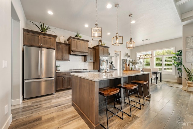 1071 W Rose Quartz St, Kuna, ID 83634 - kitchen featuring stainless steel appliances, baseboards, a kitchen island with sink, light wood-style flooring, and recessed lighting