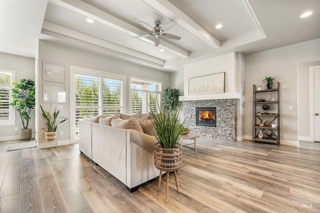 1071 W Rose Quartz St, Kuna, ID 83634 - living area with light wood finished floors, a stone fireplace, ceiling fan, baseboards, and beamed ceiling