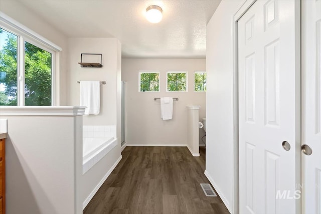 entryway with dark wood-type flooring, visible vents, plenty of natural light, and baseboards