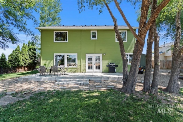 back of house featuring a lawn, fence, french doors, and a patio