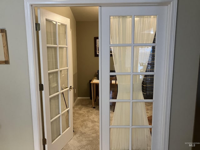 entryway with french doors and light colored carpet