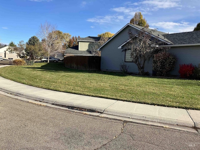 view of home's exterior featuring a lawn and fence