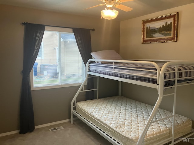 carpeted bedroom with ceiling fan, visible vents, and baseboards