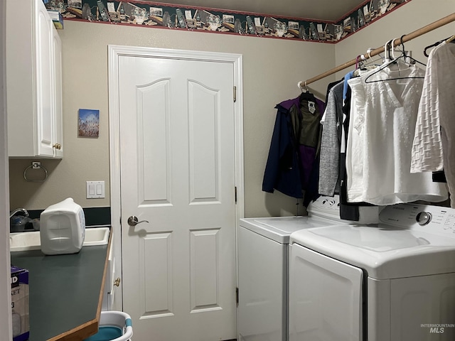 clothes washing area featuring washer and dryer and cabinets