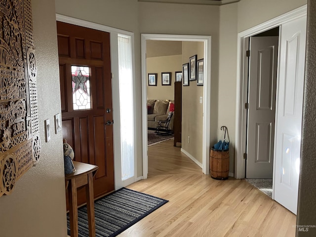 foyer entrance with baseboards and wood finished floors