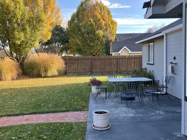 view of yard with a patio area, fence, and outdoor dining space