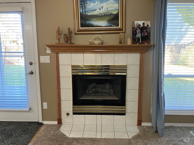 room details featuring a tiled fireplace and carpet flooring