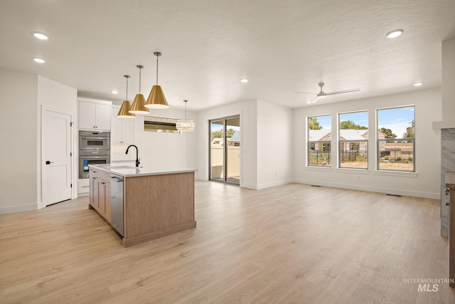 1724 Black Elm, Star, ID 83669 - kitchen with appliances with stainless steel finishes, recessed lighting, healthy amount of natural light, a kitchen island with sink, and light wood-style flooring