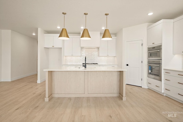1724 Black Elm, Star, ID 83669 - kitchen with light countertops, backsplash, light wood-style flooring, an island with sink, and recessed lighting