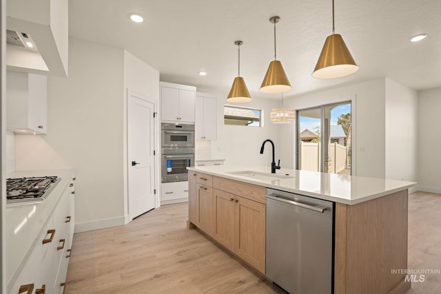 1724 Black Elm, Star, ID 83669 - kitchen with appliances with stainless steel finishes, light wood-style flooring, light countertops, a kitchen island with sink, and recessed lighting