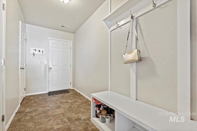 mudroom featuring a textured ceiling and tile patterned floors