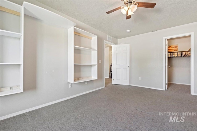 unfurnished bedroom featuring carpet, a textured ceiling, and ceiling fan