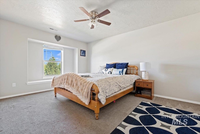 carpeted bedroom featuring ceiling fan and a textured ceiling