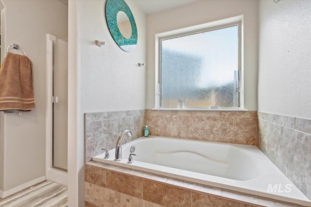 bathroom featuring shower with separate bathtub