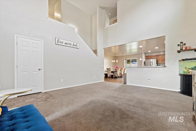 unfurnished living room featuring carpet floors and a high ceiling