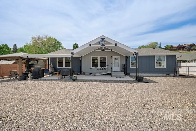 back of property with crawl space, fence, and a patio area