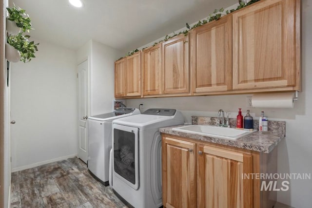laundry area featuring washer and dryer, cabinet space, wood finished floors, and baseboards